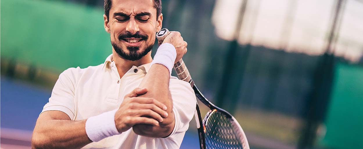 Man on tennis court with elbow pain