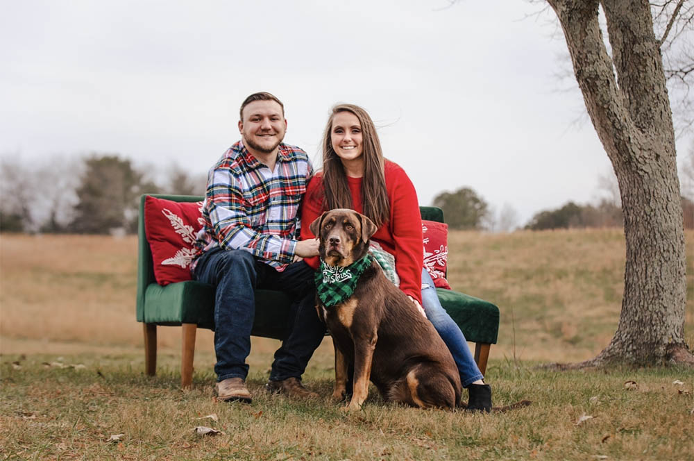 Sloane poses with her dog and husband for a family portrait.